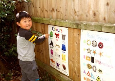 Boys studying educational materials in the garden of Cambridge nursery