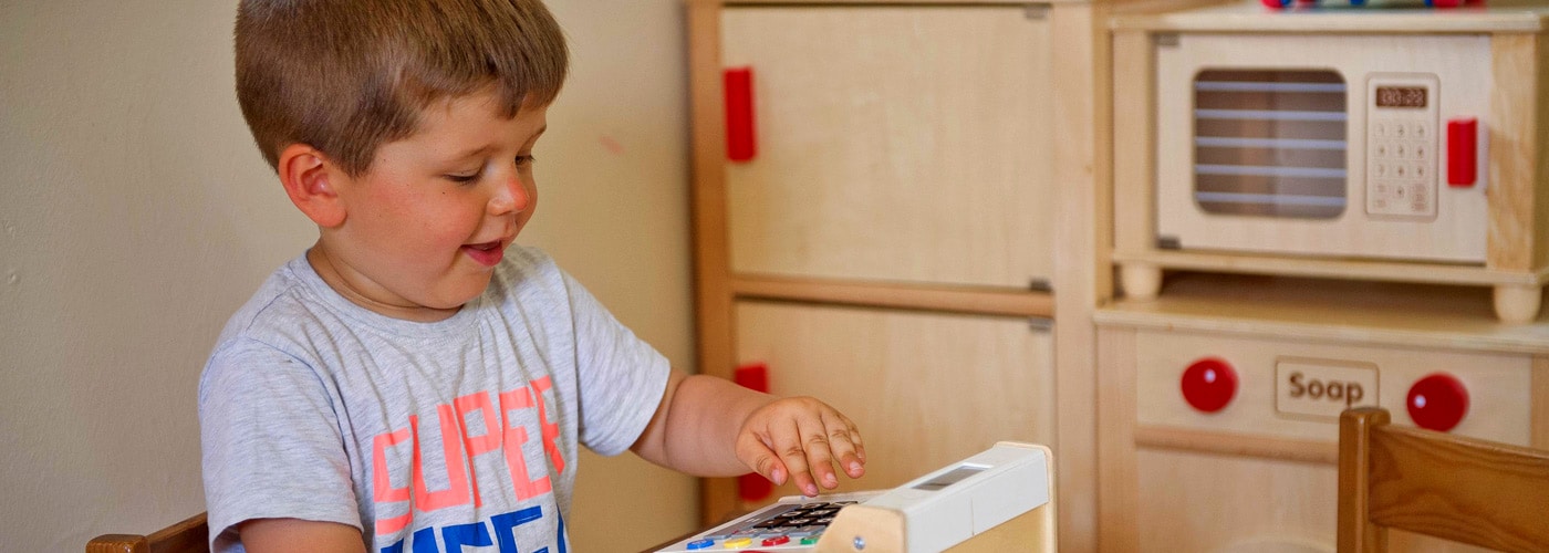 Boy playing with a toy cash register