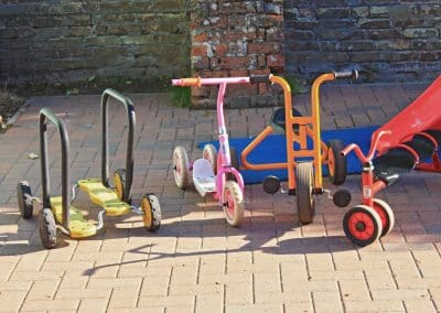 Outside trikes and scooters in the garden of Godmanchester preschool